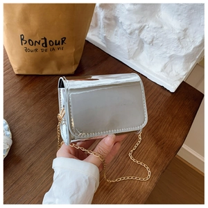 Detail of silver laser mirror finish mini crossbody bag with golden chain strap