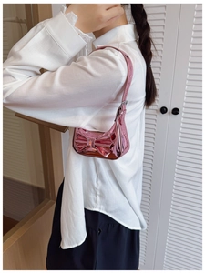 Detail of pink metallic laser finish shoulder bag with a large sweet bow decoration