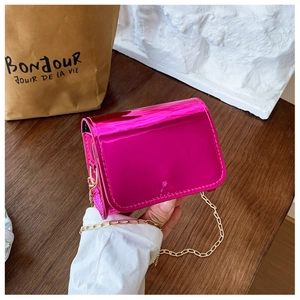 Detail of mini laser-finish crossbody bag in fuchsia pink with gold chain strap