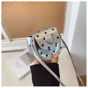 Detail of silver polka dot crossbody bag with a cute 3D heart buckle and slim strap