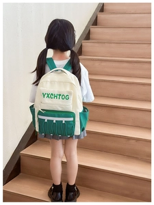 Detail of children's color-block backpack with reflective strips and side mesh pocket