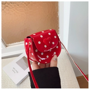 Detail of red polka dot mini bag for girls featuring a 3D heart and shiny patent leather