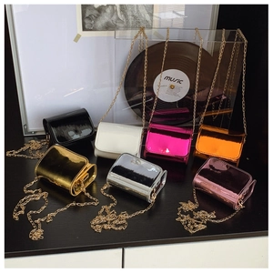 Macro shot of colorful mini shiny patent leather crossbody chain bags for kids in seven colors