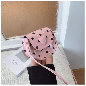 Detailed view of pink polka dot kids crossbody bag with a 3D heart and glossy finish