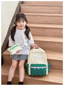 Matching kids backpack and small pouch set in beige and green featuring reflective strips