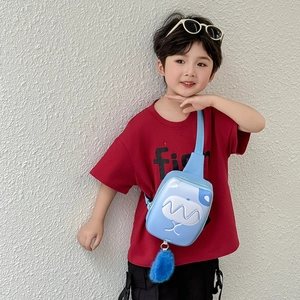 Blue kids chest bag with white cartoon face and plush ball charm on a boy model