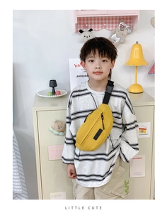 Marsupio giallo in nylon per bambini con tracolla regolabile indossato da un bambino