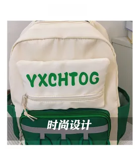 Close-up of cream and green contrasting canvas backpack with bold letter logo and pocket