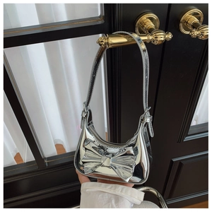 Detail of silver metallic mirror finish on children's handbag with large bow decoration