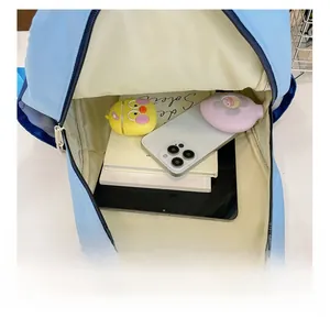 Macro detail showing spacious interior of the light blue backpack with tablet and books