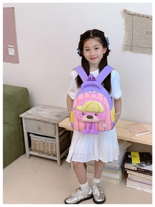 Sac à dos enfant rose et violet avec chien 3D porté par un enfant dans un décor cosy