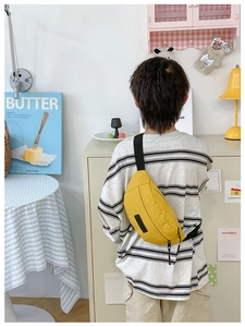 Dettaglio posteriore di un bambino con un borsello giallo in nylon impermeabile