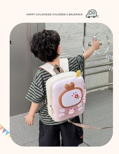 Pink egg-shell kids backpack with retro TV design and safety leash in a lifestyle setting