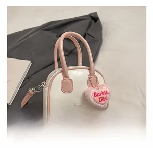 Pink and white shell-shaped kids handbag featuring plush heart charm and embroidery
