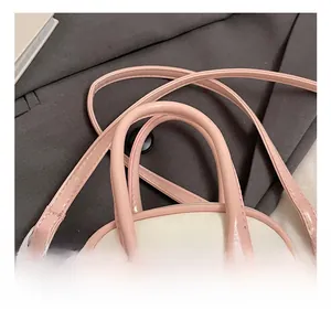 Detail of comfortable rounded leather handle and silver metal buckle on shell bag