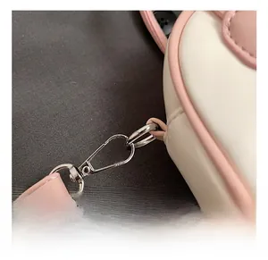 Detail show of durable silver metal hook and pink leather strap on kids shell bag