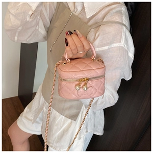 Mini sac matelassé rose avec perles et bandoulière chaîne porté par un modèle