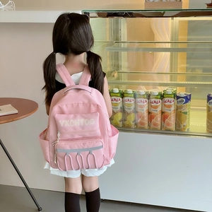 Pink school backpack for kids with contrast letters and multiple pockets worn by a model