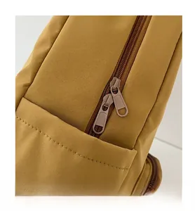 Détail des doubles fermetures éclair jaunes sur un sac à dos avec coutures uniformes