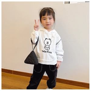 Detail einer schwarzen mini Handtasche in Dreiecksform für Kinder in der Hand