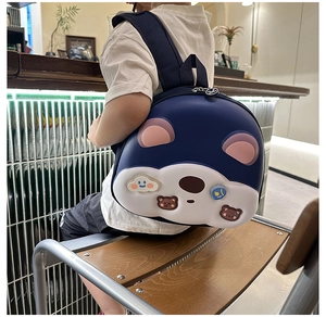 Dettaglio dello zaino rigido blu scuro per bambini con orecchie da orso in un bar accogliente