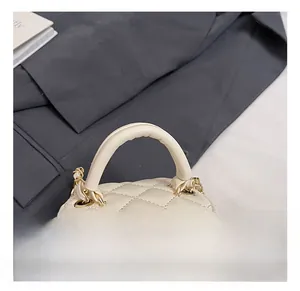 Detail of mini quilted handbags with arched handles and elegant pearl pendant accents