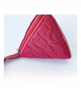 Detailaufnahme des herzgesteppten rosafarbenen Stoffs und Reißverschlusses der Tasche