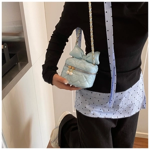 Detail of light blue quilted leather bag with bow, Hello Kitty motif and gold chain strap