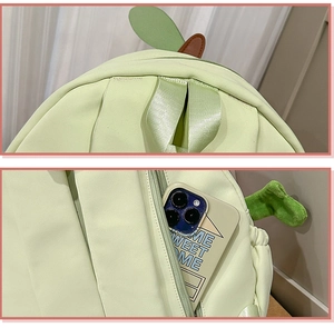 Detail view of the green backpack featuring durable metal zippers and a sturdy webbed handle