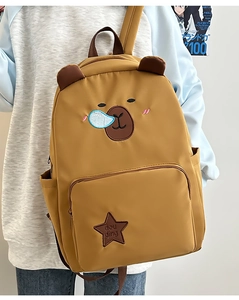 Détail du sac à dos Capybara jaune avec oreilles d'ours et broderie d'étoile