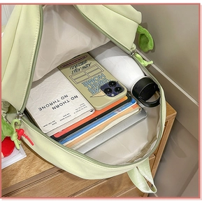Close-up of spacious backpack interior holding books, tablet, and a water bottle