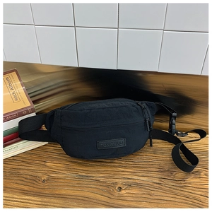 Dettaglio del marsupio in nylon nero per bambini con fibbia e tracolla regolabile