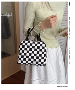 Close-up of checkered canvas lunch bag featuring black and white pattern with hand strap