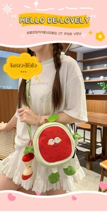 Detail of round watermelon crossbody bag with a cute apple plush charm on model