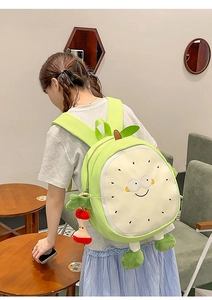 Side view of a cute cartoon guava backpack with character limbs and apple charm accessory