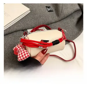 Mini borsa a cilindro crema con corda rossa intrecciata e ciondolo a cuore