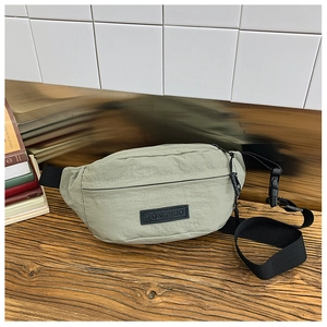 Dettaglio del marsupio in nylon verde chiaro con cinturino nero e toppa in pelle TONGHUO