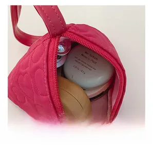 Innenansicht und herzförmige Steppung dieser pinkfarbenen Mini-Umhängetasche