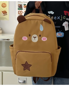 Vue détaillée d'un sac à dos marron avec visage d'ours et broderie d'étoiles
