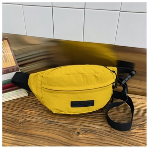 Dettaglio del marsupio in nylon giallo brillante con etichetta logo nera e fibbia