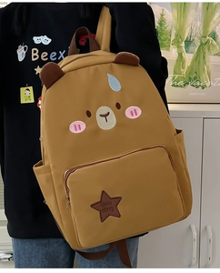 Détail d'un sac à dos ours brun mignon avec broderie et décoration en forme d'étoile