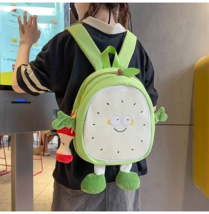 Detail of cute green fruit-shaped backpack with 3D plush arms and apple pendant