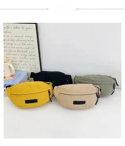 Dettaglio di marsupi in nylon per bambini nei colori giallo, beige, nero e verde