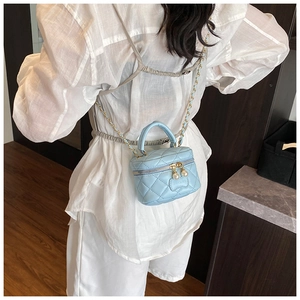 Détail du mini sac matelassé bleu clair avec fermeture éclair perle sur l'enfant