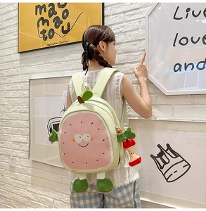 Detail of sweet fruit-shaped backpack with cute 3D cartoon arms and legs on girls back