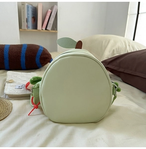 Detailed close-up of fruit-shaped green shoulder bag with 3D leaf and zipper detail