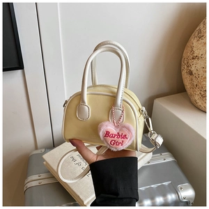 Detail of yellow mini shell bag with pink Barbie Girl heart pendant and white strap