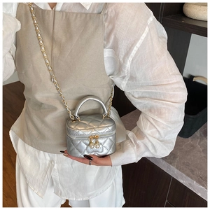 Détail du mini sac vanité argenté matelassé avec bandoulière et tirette en perles