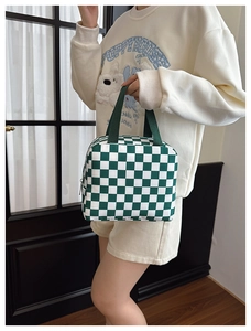Detailed view of the green and white checkered lunch bag with sturdy canvas handles