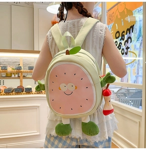 Detail of sweet green fruit backpack with cute cartoon face and soft plush limbs